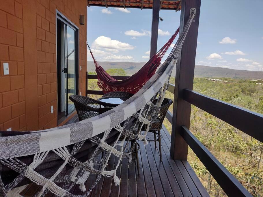 a hammock on the porch of a house with a view at Casa do Rudá na Chapada dos Veadeiros in Alto Paraíso de Goiás