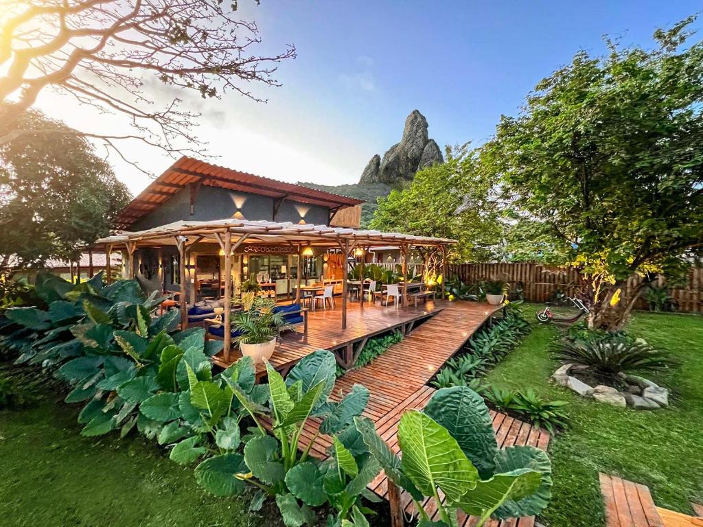 uma casa com um deque de madeira num jardim em Pousada Moana em Fernando de Noronha