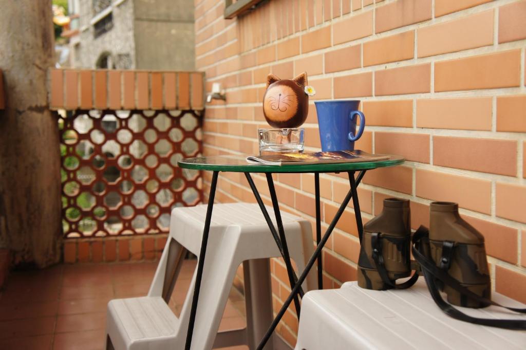 a table with a cup on top of it next to two chairs at Jiufen B&B Uncle Xie's in Jiufen