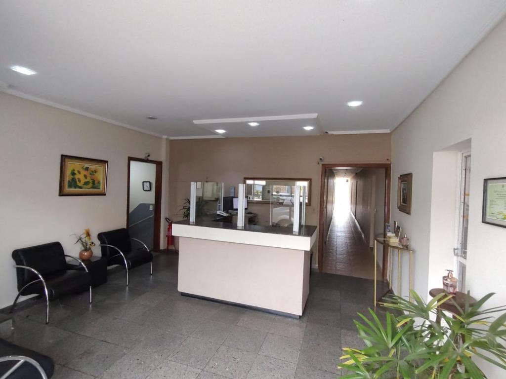 a waiting room with chairs and a reception counter at Hotel Mirante da Serra in Ouro Branco