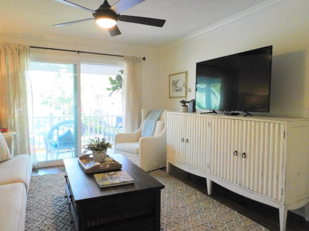 a living room with a flat screen tv and a couch at Q4 Professionally decorated upstairs beautiful soothing colors close to back pool in Saint Simons Island