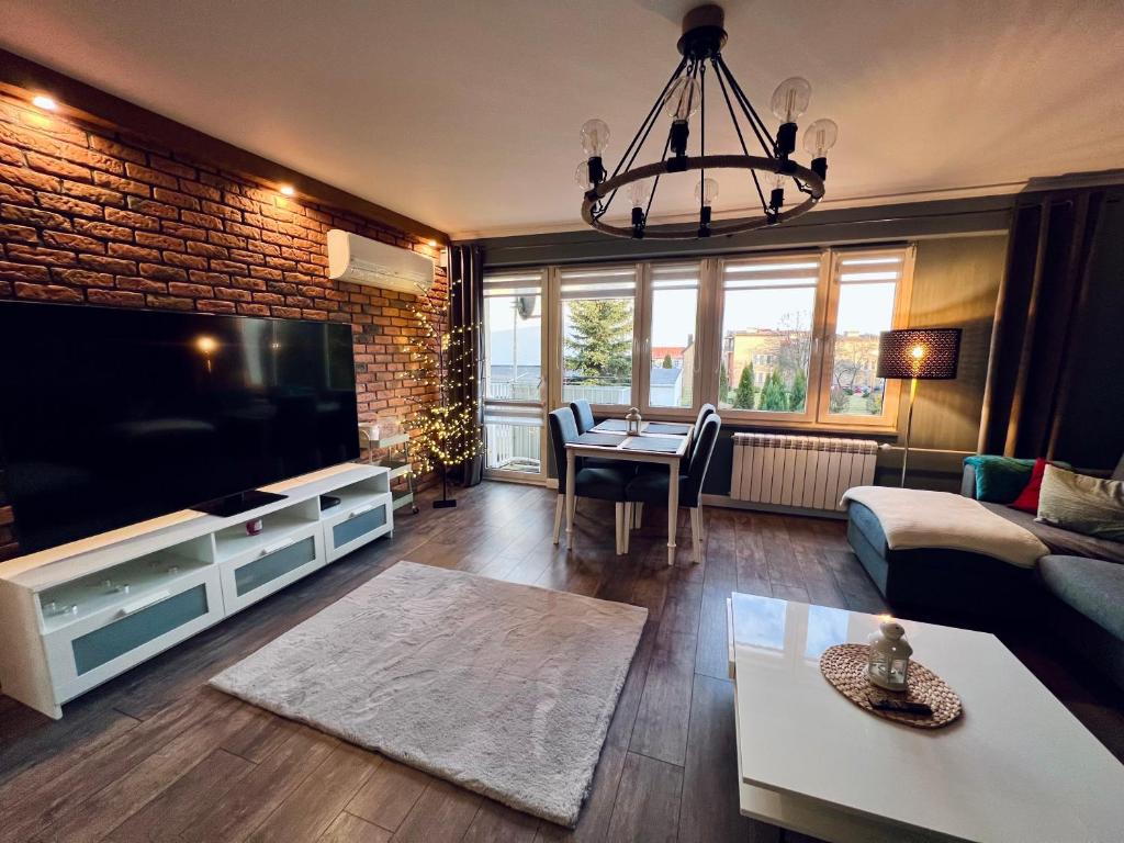 a living room with a large flat screen tv at Apartment of Love in Olecko