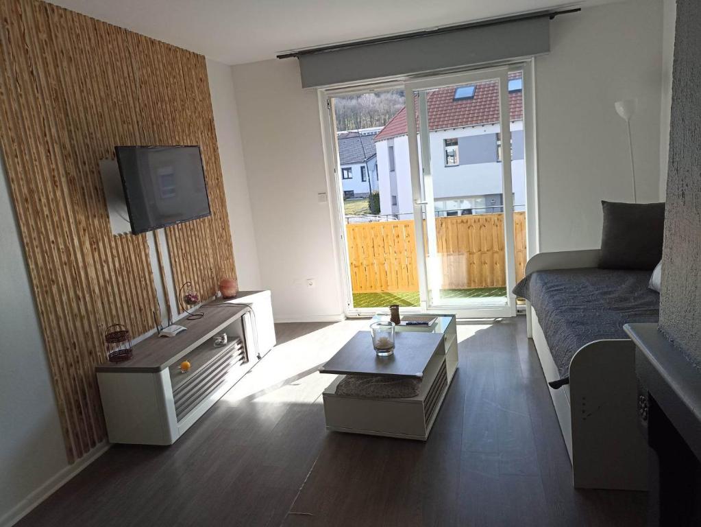 uma sala de estar com um sofá e uma mesa de centro em Appartement Gauche avec balcon em Hargarten-aux-Mines
