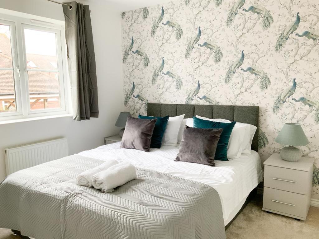 a bedroom with a large white bed with a wall at Barley House in Andover