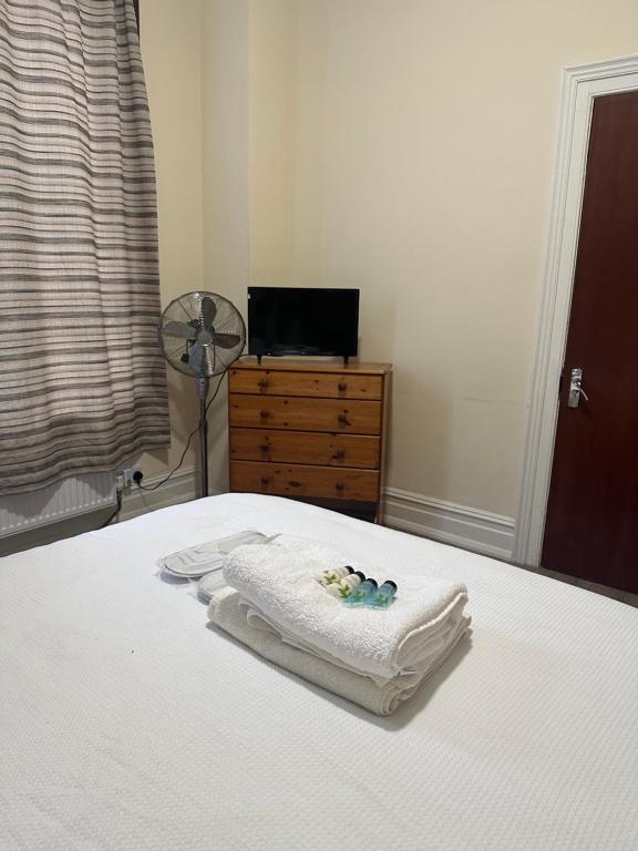 倫敦的住宿－Valentines Inn，一间卧室配有带毛巾和梳妆台的床
