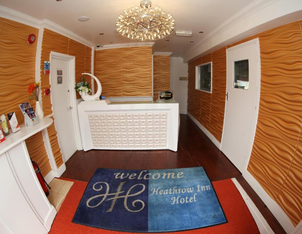 a kitchen with a welcome rug on the floor at Heathrow Inn Hotel in Hillingdon