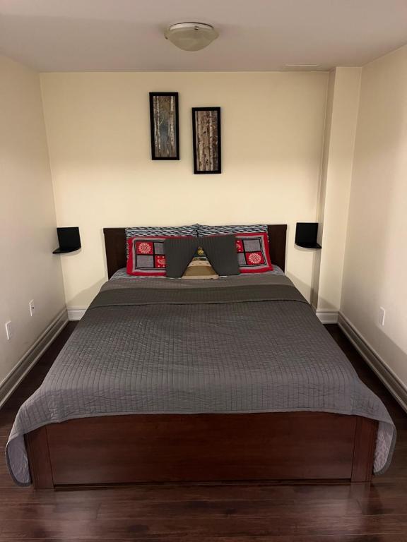 1 dormitorio con 1 cama grande con almohadas rojas en Cozy & Spacious Suite with Private Bathroom near Toronto Airport ! en Mississauga