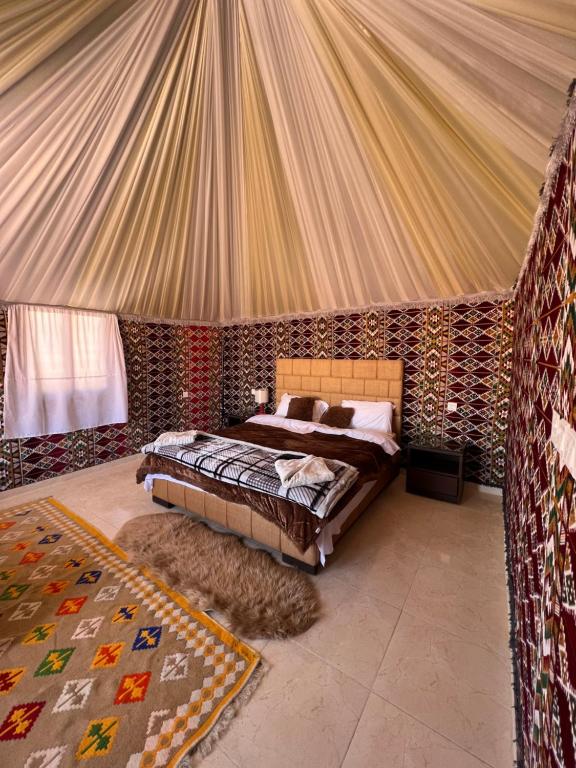 a bedroom with a bed in a tent at Wadi Rum Sunset Camp in Wadi Rum
