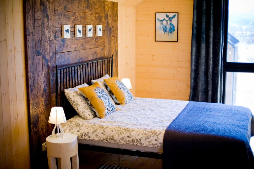 a bedroom with a bed with yellow and blue pillows at Dzikie Lisko - Apartament z klimatyzacją in Lesko