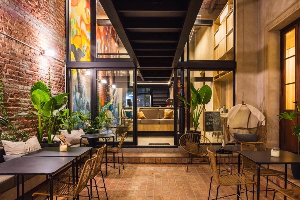 un restaurante con mesas y sillas y un sofá en Faz Hostel en Córdoba