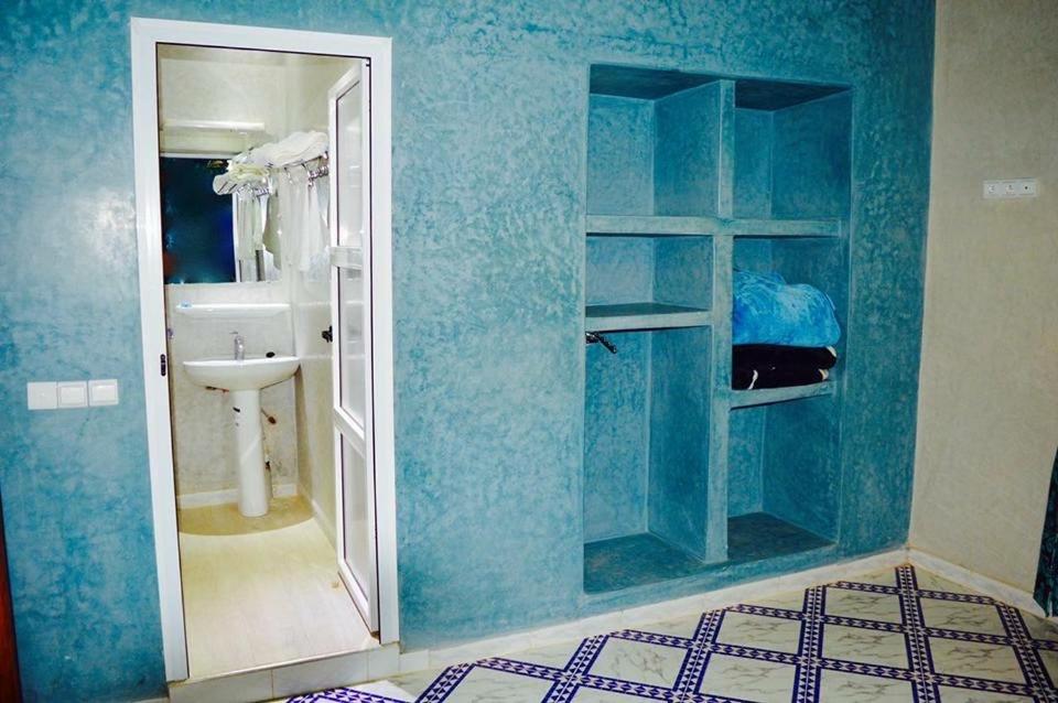 ein blaues Bad mit einem Waschbecken und einer Dusche in der Unterkunft Riad Sadoq in Merzouga