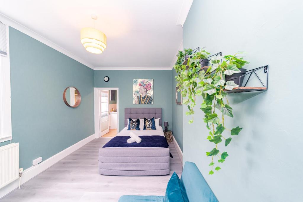 a bedroom with a bed and a blue wall at Stunning STUDIO Apartment in Hove Minuets away to BRIGHTON BEACH in Brighton & Hove