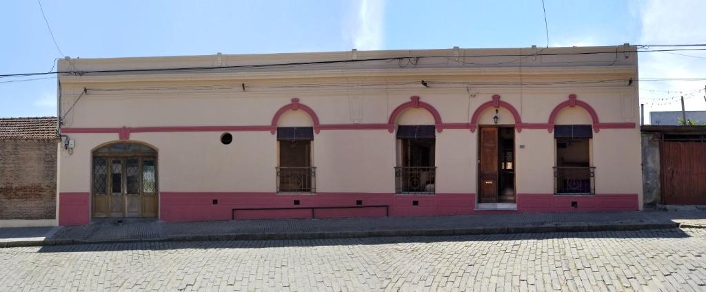 un edificio blanco con arcos y puertas en una calle en Casa Rodo 53, en Rocha