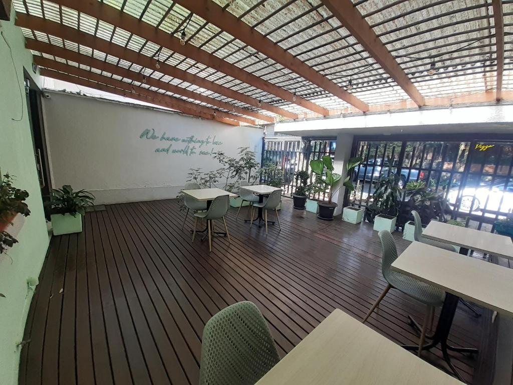 a room with tables and chairs in a room with windows at Cocobamboo Hotel in Medellín