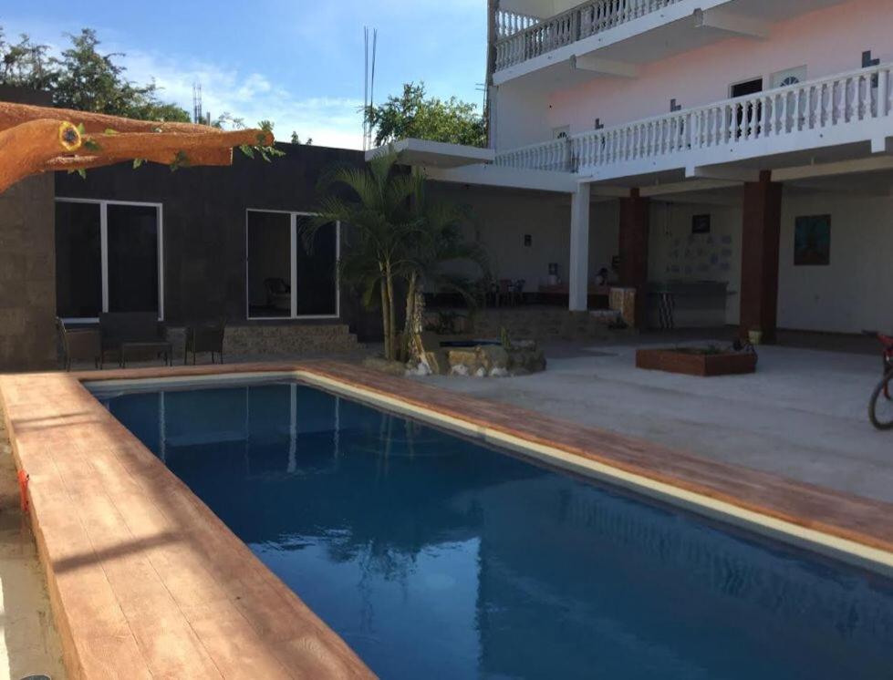 uma villa com piscina em frente a uma casa em CENTRO NATURISTA Y BUDISTA em La Cruz de Loreto