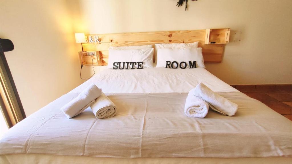 uma grande cama branca com duas almofadas em El Bosque Suites&Room By Mila Prieto em El Bosque