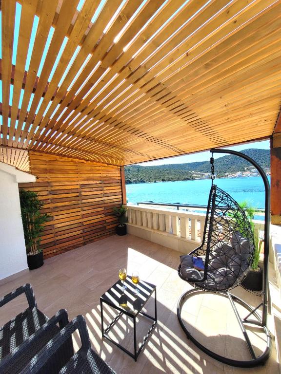 a patio with a swing on a deck at Kupinica Apartment in Vinišće