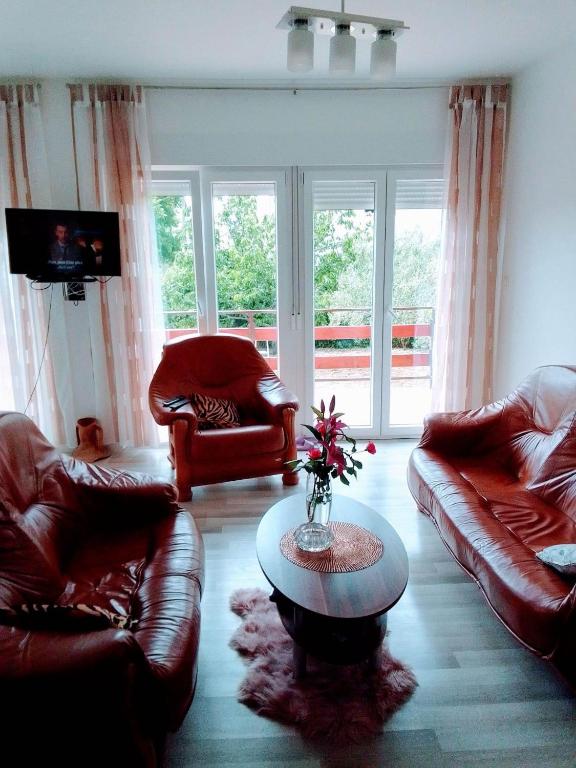 a living room with leather couches and a table at Holiday home Buljat in Kaštela