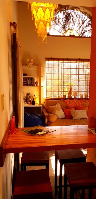 uma sala de estar com uma mesa e um sofá em Morada de encuentro em Capilla del Monte