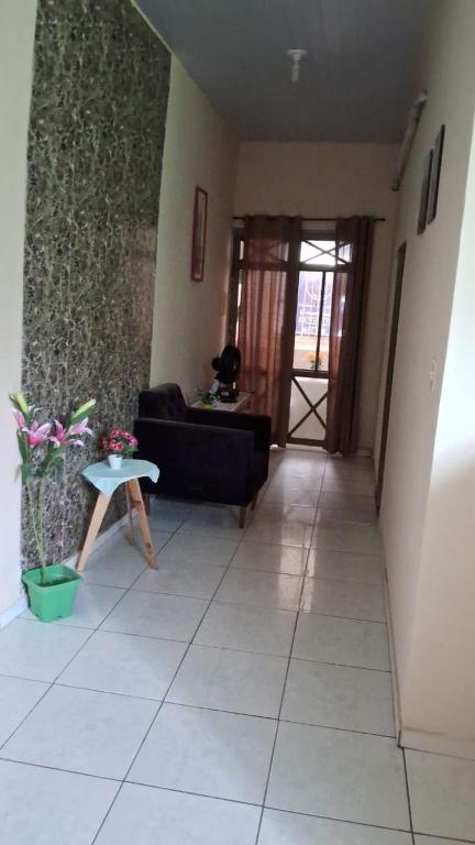 a living room with a black couch and a table at Apto em São Bráz in Belém
