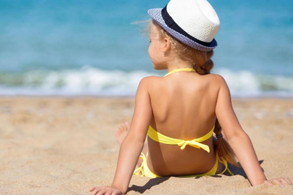 mała dziewczynka siedząca na plaży w obiekcie Mijas Costa - Beachside Apartment-B w mieście Mijas Costa