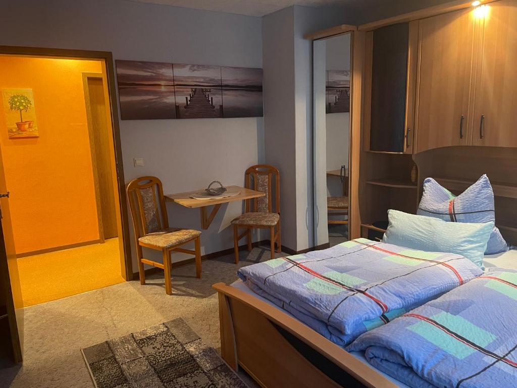 Schlafzimmer mit einem Bett, einem Tisch und Stühlen in der Unterkunft Haus Wiesenblick in Walkenried