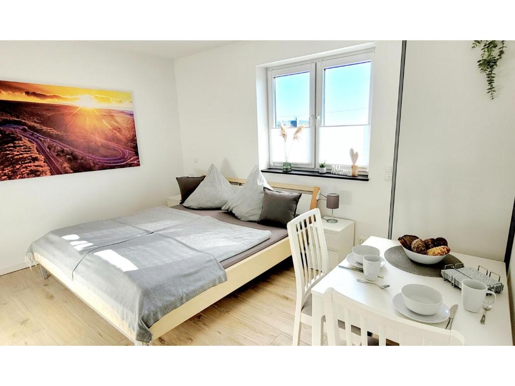 um pequeno quarto com uma cama e uma mesa com uma mesa; em Ring Apartment am Nürburgring em Herresbach