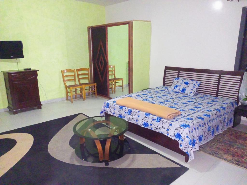 a bedroom with a bed and a table and chairs at Complexe le QG in Niaga