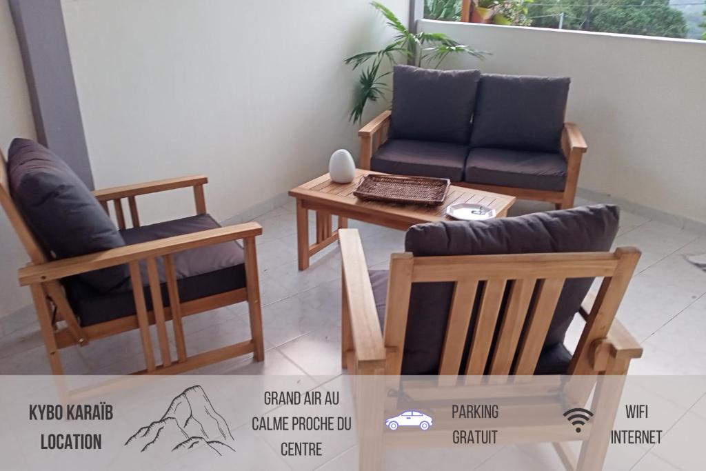 Zimmer mit 2 Stühlen, einem Tisch und einem Sofa in der Unterkunft Paradis Caché - Confort Terrasse - Kybo Karaib Location - pkg - Mtgne in Sainte-Marie