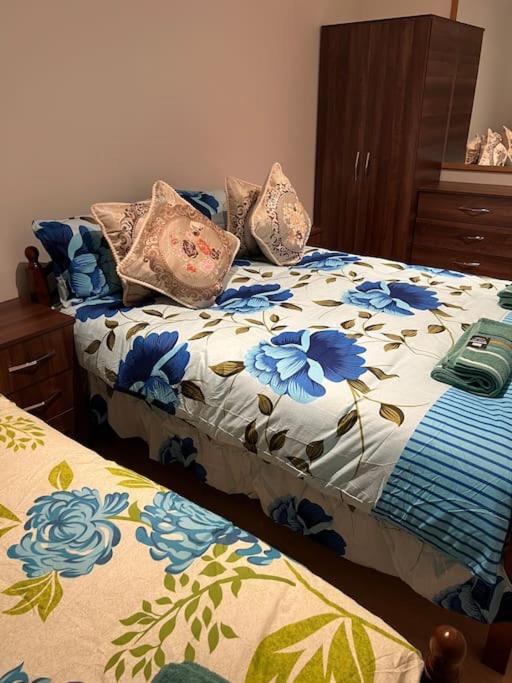 Un dormitorio con una cama con flores azules. en 011- One bedroom in Ealing F3 en Ealing