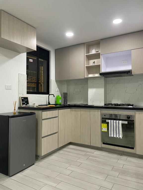 una cocina con electrodomésticos y armarios de acero inoxidable en Hermoso apartamento moderno, excelente ubicación cerca al centro histórico, en Bogotá