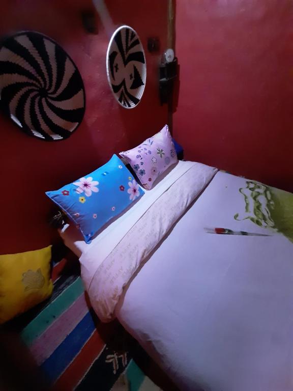 a bed with colorful pillows on it in a room at Hike and Chill Homestay in Tinerhir
