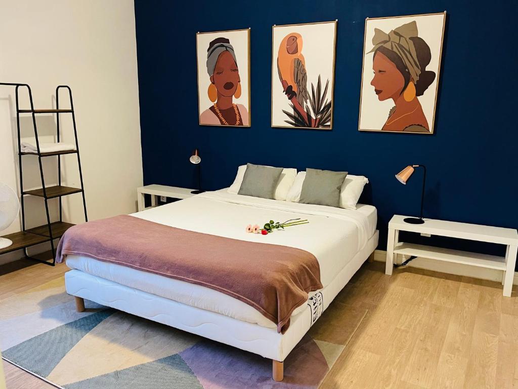 een slaapkamer met een bed met vier foto's aan de muur bij Casa Grande in Romilly-sur-Seine