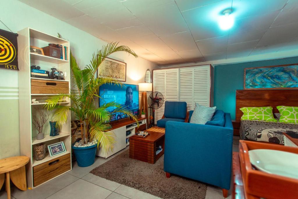 a living room with a blue couch and a table at PALM Springs Bed & Breakfast in Limbe