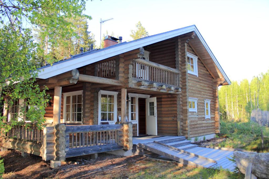eine Blockhütte mit einer Veranda und einer Terrasse in der Unterkunft Aapishovi Chalet in Tapio