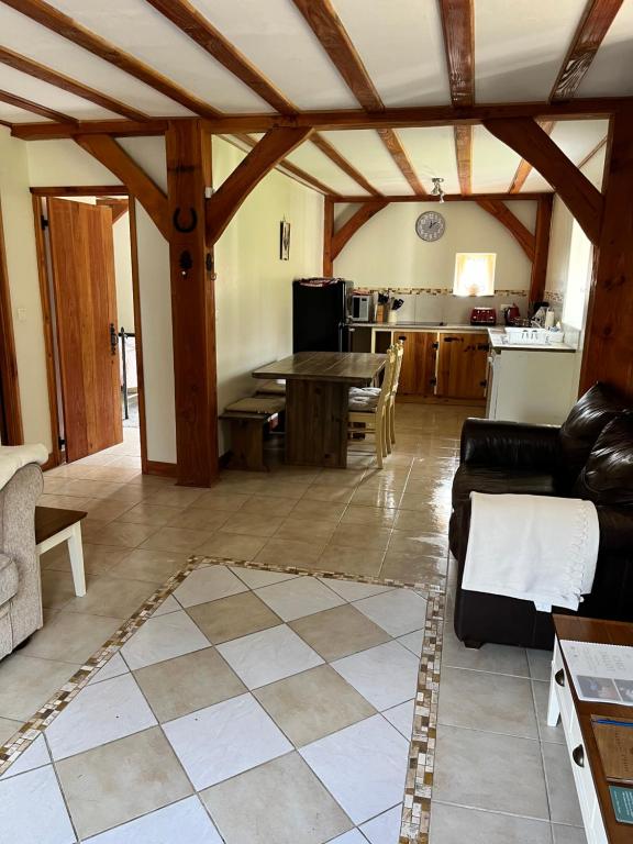 sala de estar con sofá y cocina en Chez Jallot - Lower Gite en Vidaillat