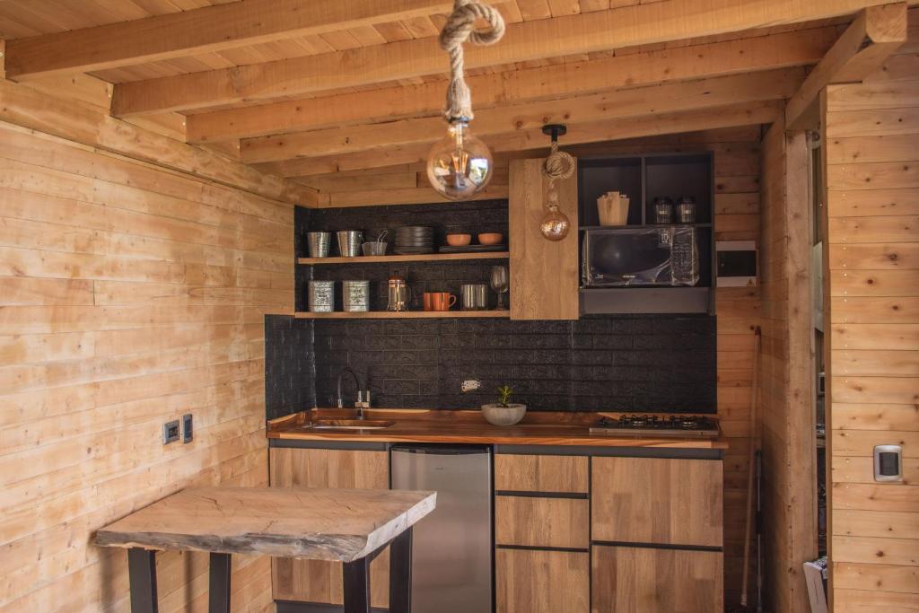cocina con paredes de madera y encimera con fregadero en Giüg Refugio en Medellín