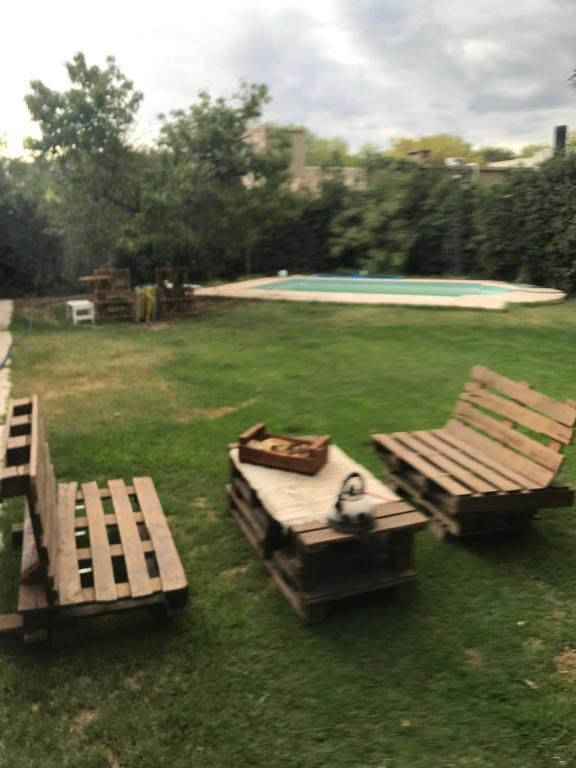 duas mesas de piquenique na relva ao lado de uma piscina em Casa Los Cerezos de Chacras em Mayor Drumond