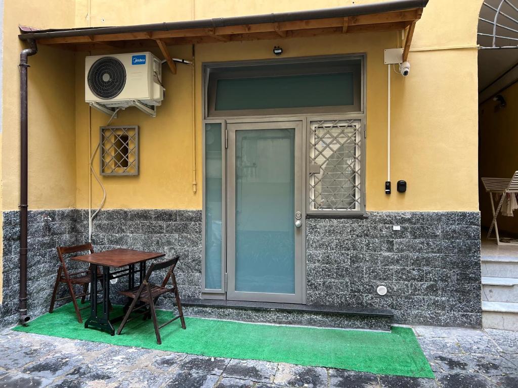 a door with a table and chairs in front of a house at Casa Fiore in Naples