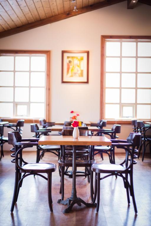 a dining room with tables and chairs and windows at Guesthouse Fludir in Fludir