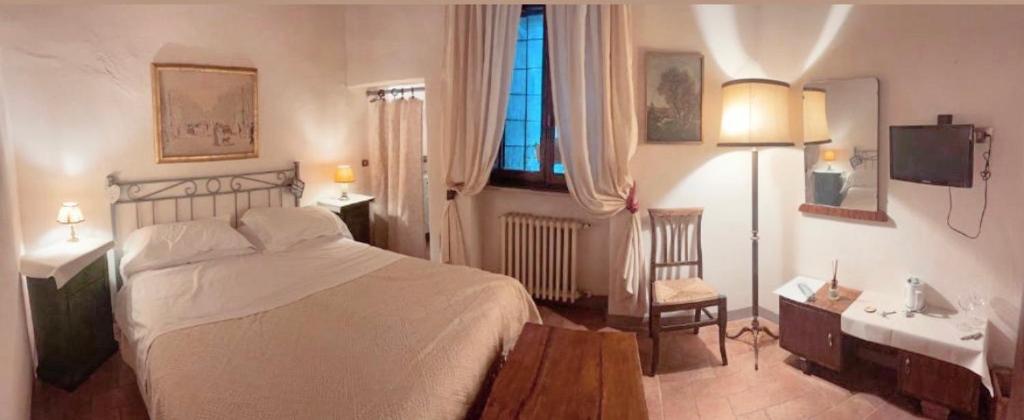 a bedroom with a large bed and a window at Guesthouse da Idolina dal 1946 in Montalcino