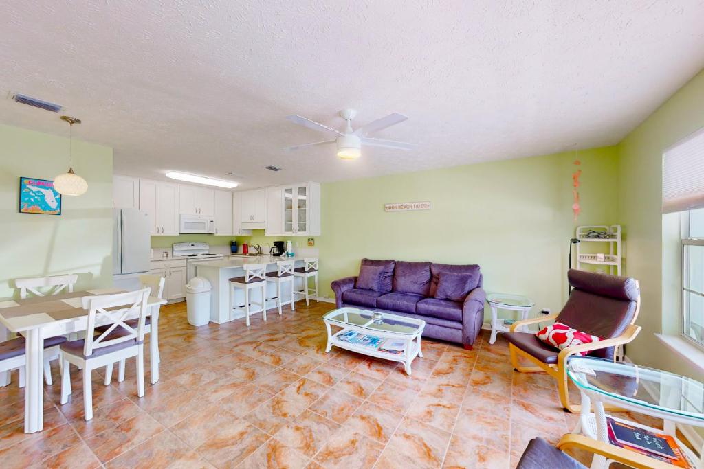 a living room with a purple couch and a kitchen at Wendwood Condominiums F2 in Panama City Beach