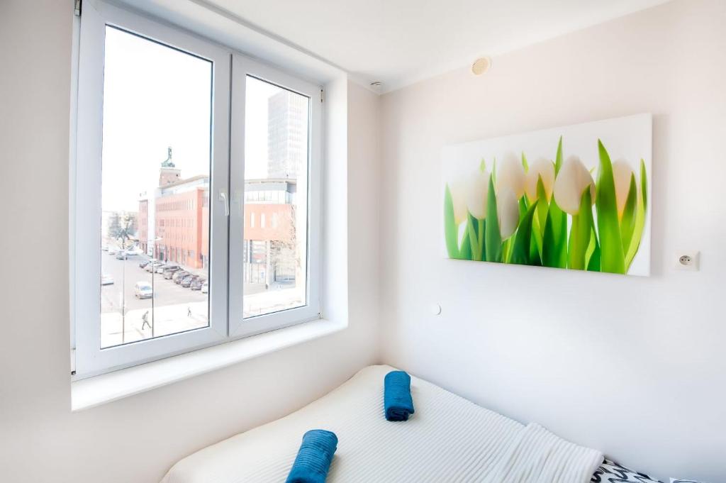 Habitación blanca con ventana y sofá en Ul RAJSKA 1E 5 APARTAMENTY ZRESETUJ SIĘ W GDAŃSKU, en Gdansk