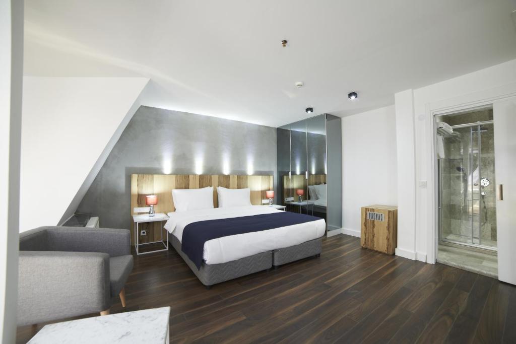 a bedroom with a bed and a chair and a couch at En Otel Karaca in Eskisehir