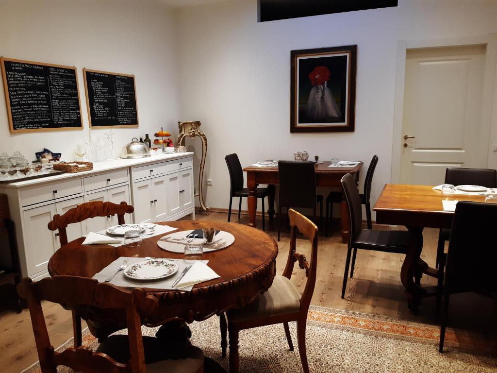 comedor con mesa, mesas y sillas en B&B S. Trinità 18 Suites & Rooms en Trento