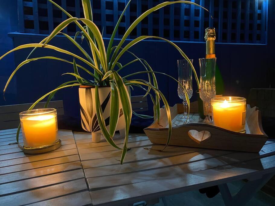 a table with candles and a potted plant on it at Cowes Cottage in Cowes