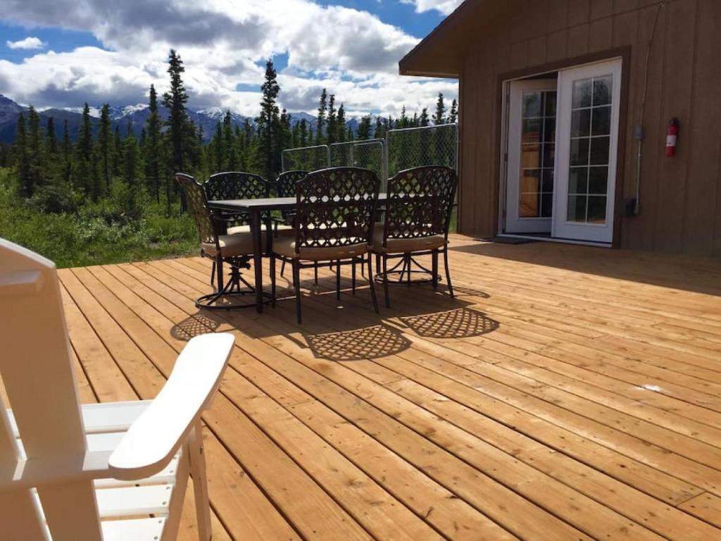 a patio with a table and chairs on a deck at Denali Park 2 Bedroom Mom in Law in Healy