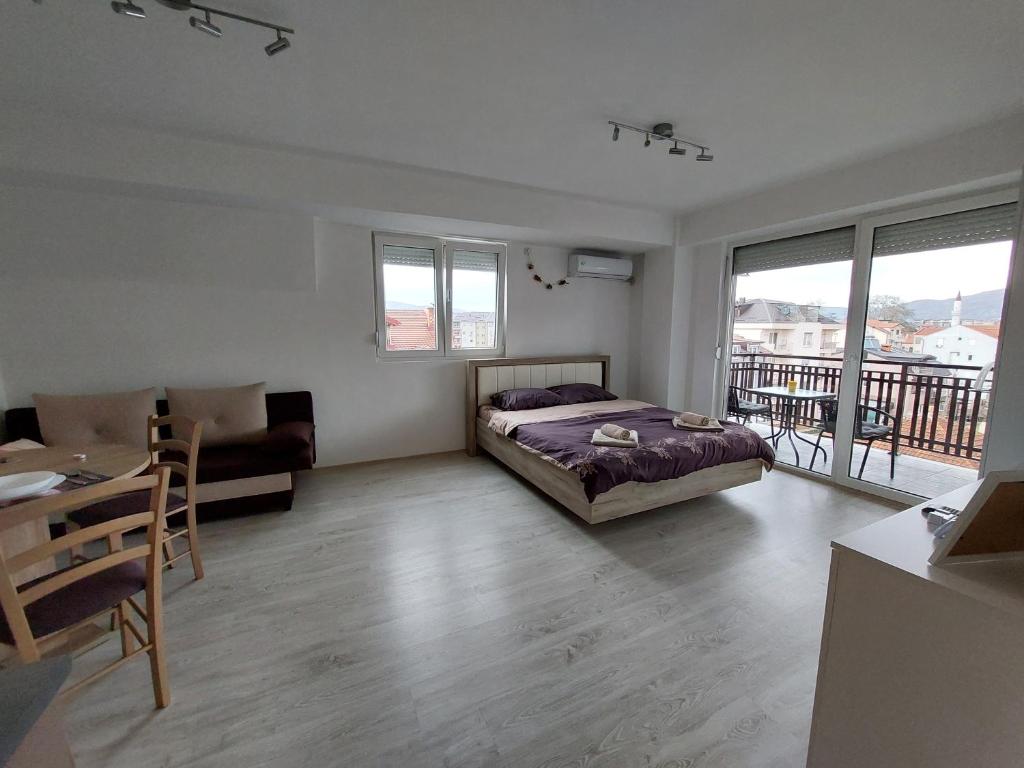 - une chambre avec un lit, une table et un balcon dans l'établissement Dzusy Apartments, à Ohrid