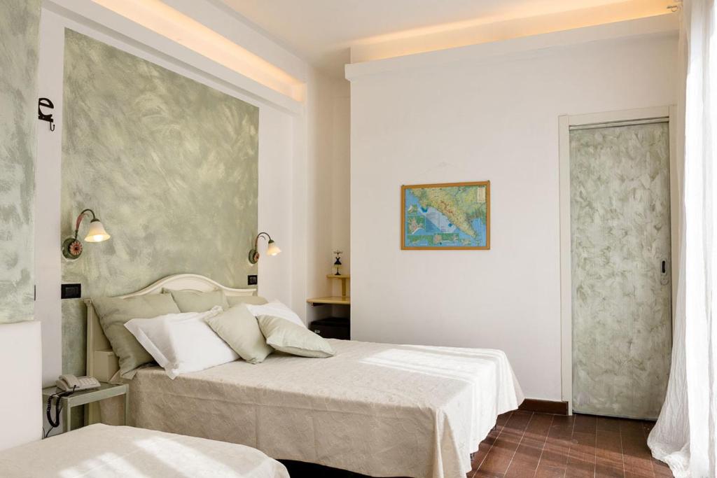 a bedroom with two beds and a painting on the wall at Hotel Marina in Monterosso al Mare