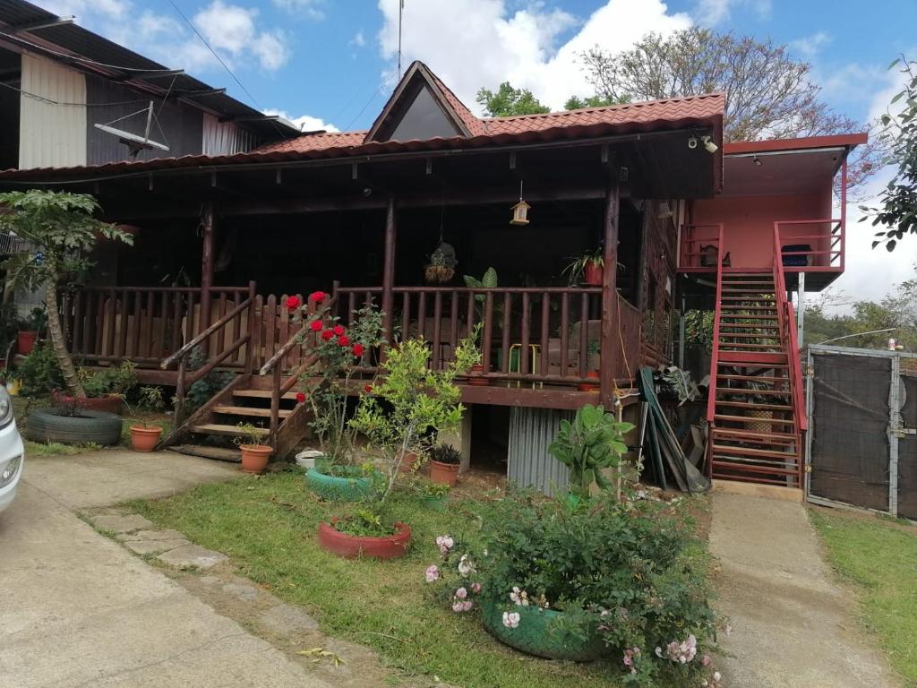 a house with a porch and some plants at Finca pedacito de cielo in Paraíso